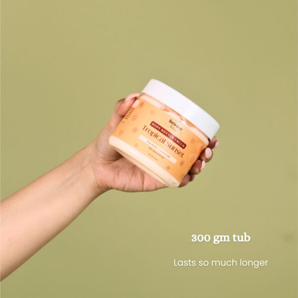 Model holding Tropical Sunset Coconut Body Butter closed jar