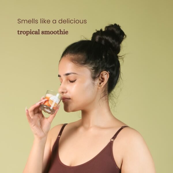 Model smelling Tropical smoothie scented soy wax candle